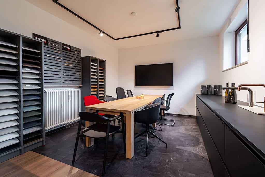 Besprechungstisch mit Musterwand und Küche im Showroom